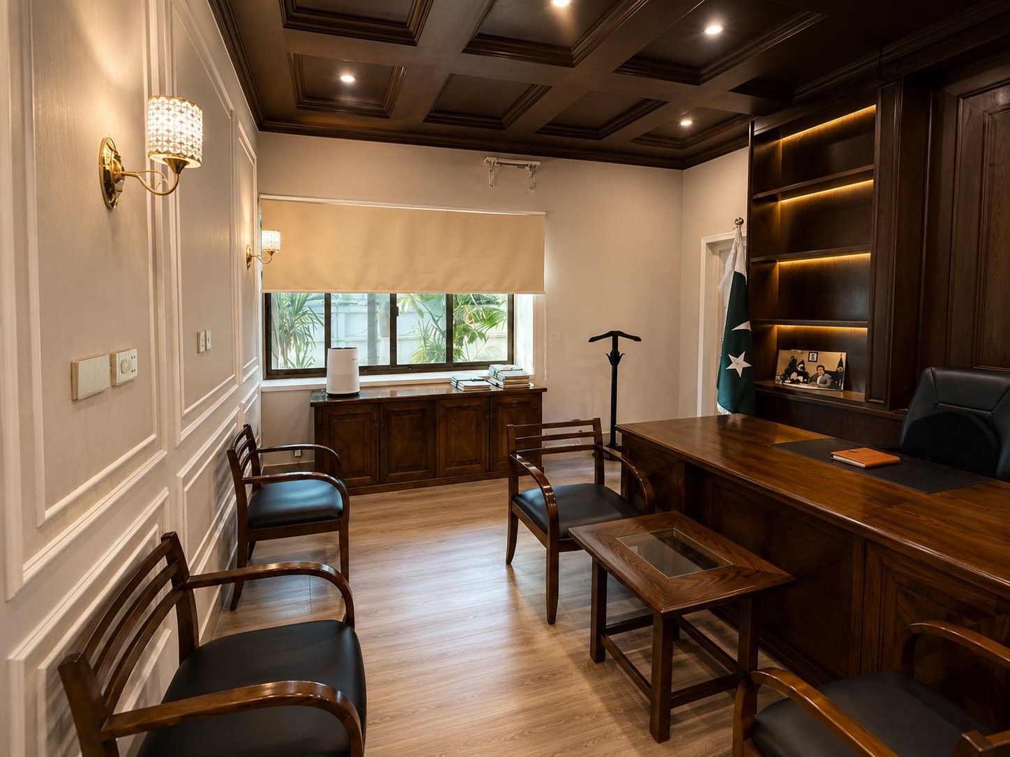 Office with a wood desk, panelled walls, national flag and backlit shelving