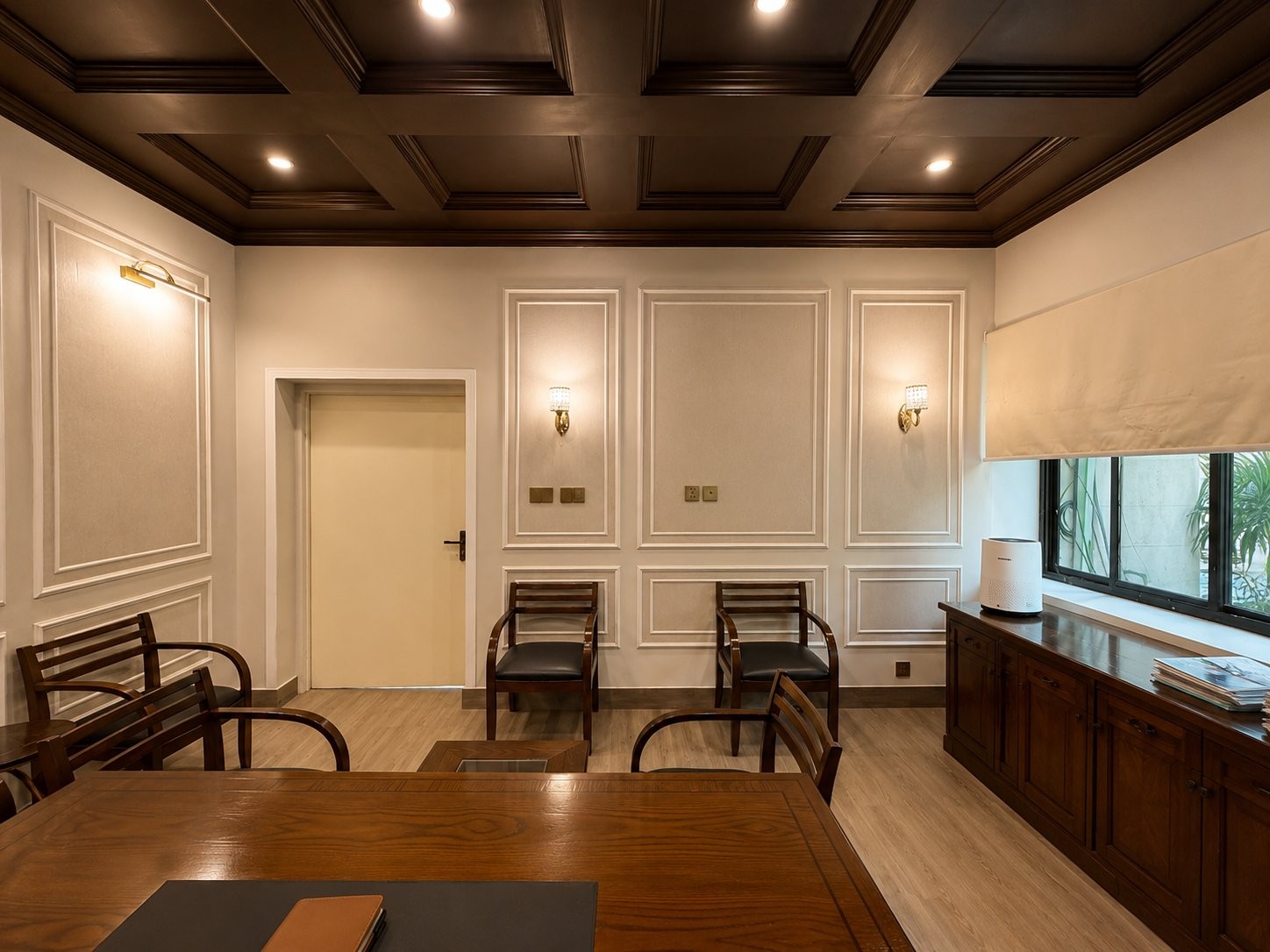 Panelled meeting and waiting area with a coffered timber ceiling and wood armchairs