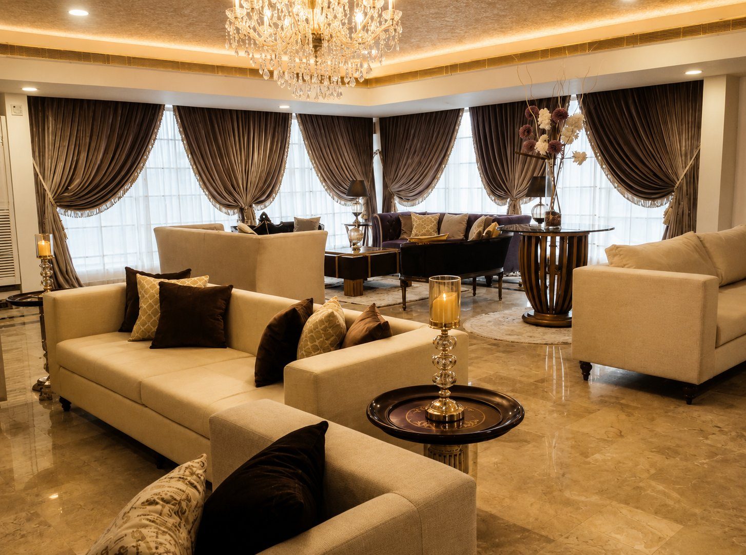 Wide lounge view with cream sofas, chandelier and mauve velvet seating