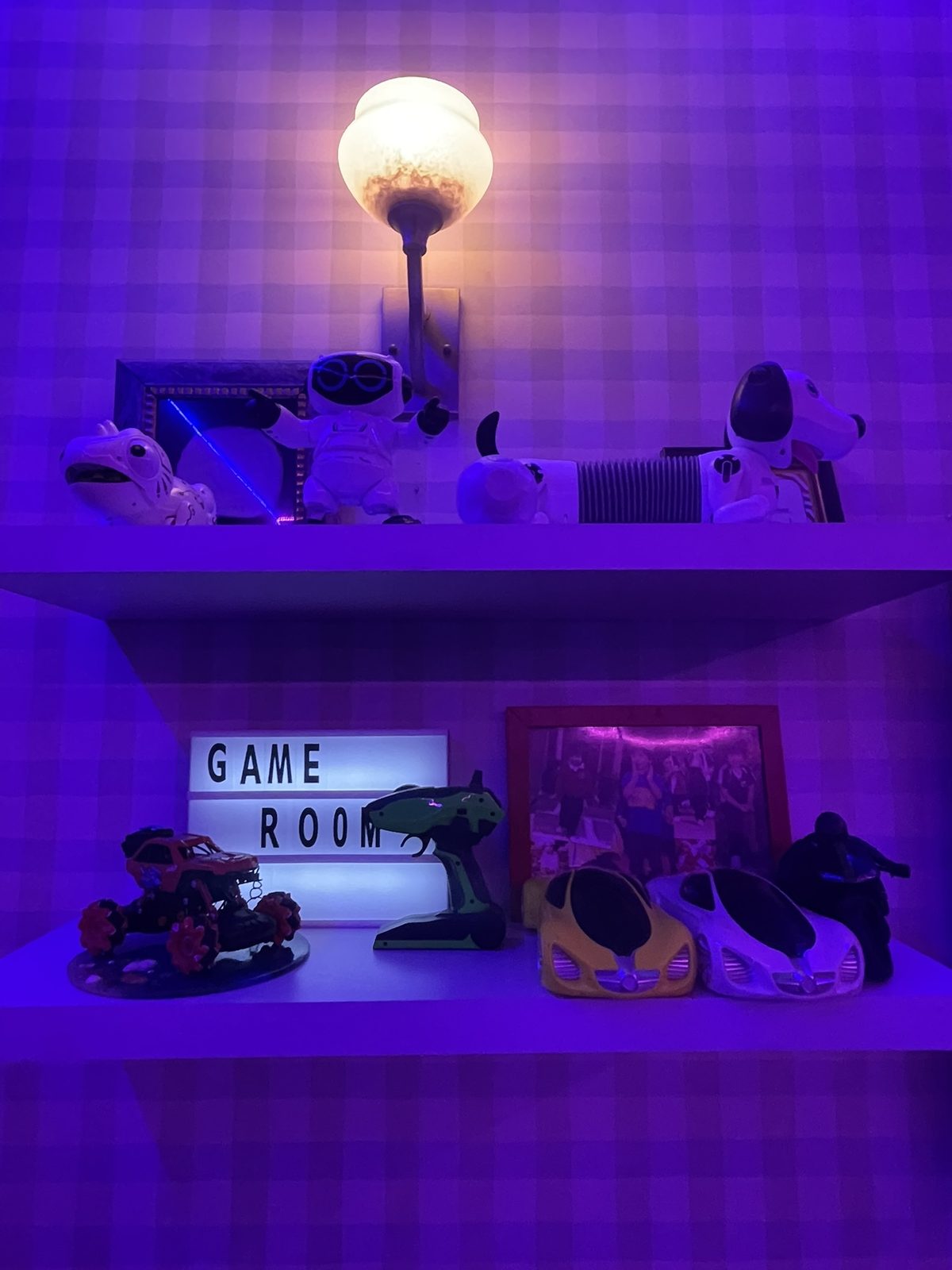 Shelf styled with robot toys, lamp and Game Room light box sign